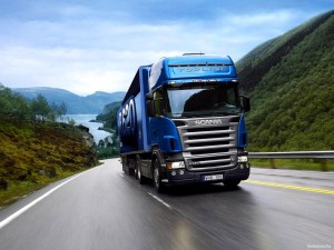 Imagen de Trailer Scania Azul conduciendo en la carretera mojada